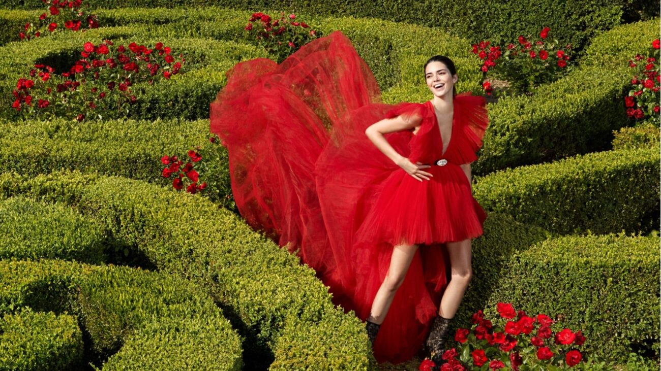 Kolekcja H&M z Giambattista Vallim. Kobieta w czerwonej sukience w ogrodzie z labiryntem.