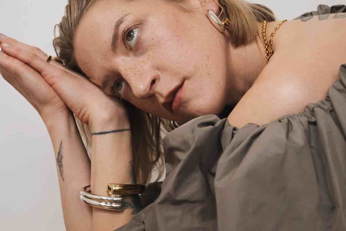 Lara Gessler w kampanii Tous MMC Studio, ubrana w zieloną sukienkę i charakterystyczną biżuterię Tous. Artystyczne ujęcie modelki w stylizacji MMC Studio z bransoletkami TOUS – moda i biżuteria w harmonii.